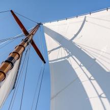 a large white sail on a tall ship