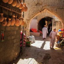 eine Gruppe von Männern, die durch eine Gasse auf einem Markt gehen