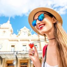 a woman wearing a hat and sunglasses eating an ice cream cone