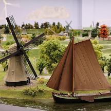 ein Modell einer Windmühle und eines Bootes im Wasser