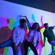 a group of people standing in front of a colorful wall