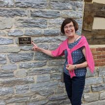 a woman standing in front of a brick wall