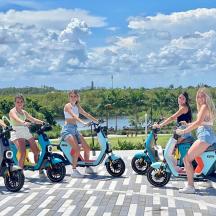 a group of women sitting on scooters