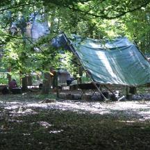 a blue tarp hanging from a tree in a park