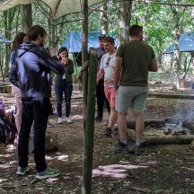 a group of people standing around a camp fire
