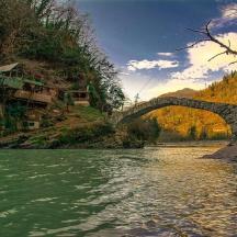 eine Brücke über einen Fluss neben einem Berg