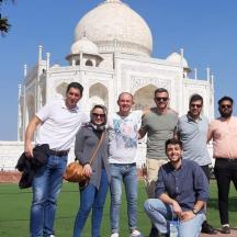 a group of people posing in front of the taj mahal
