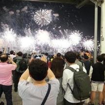 a crowd of people taking pictures of fireworks