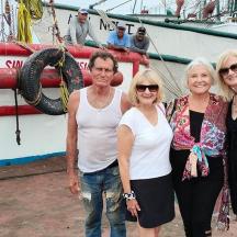 a group of people standing next to a boat