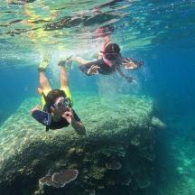 two people swimming in the water with a camera
