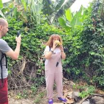 a woman taking a picture of a man with a banana
