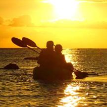 a person standing in the ocean at sunset