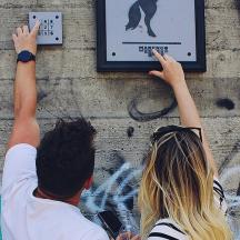 un uomo e una donna che cercano di raggiungere un cartello su un muro
