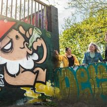 un grup de persones dretes en un mur amb grafits