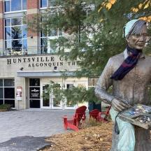 a statue of a man sitting in front of a building