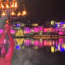 eine Frau, die nachts einen Lichtmast im Wasser hält
