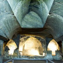 a stone building with arches and lights on it