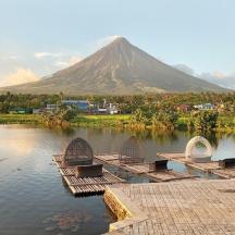 a mountain in the background with benches in the water