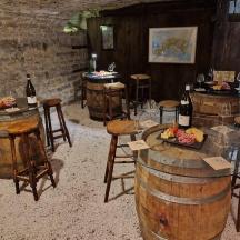 a wine tasting room with barrels and tables with wine bottles