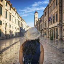 a woman in a hat walking down a street