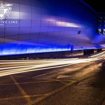 a city street with a building with blue lights