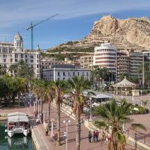 a city with a boat in the water and a mountain