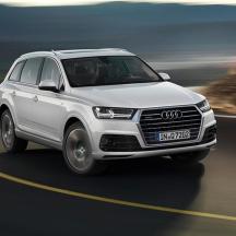 un Audi SUV blanc conduint per una carretera