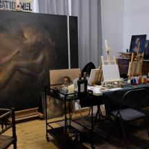 a room with a painting and a table with chairs