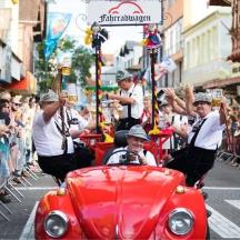 a group of people riding in an old car in a parade