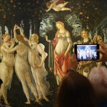 a group of people taking a picture of a painting