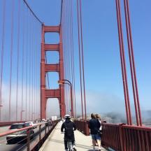 two people riding bikes on the golden gate bridge