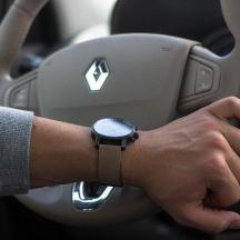 un homme conduit une voiture avec une montre au poignet