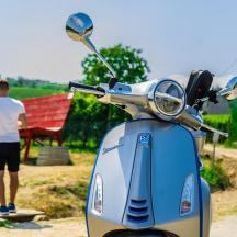 un uomo e una donna in piedi accanto a uno scooter
