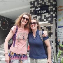 two women posing for a picture in front of a building