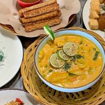 a bowl of soup on a table with plates of food