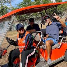 a group of people sitting in a golf cart