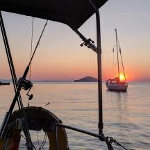 a boat in the water with the sunset in the background