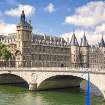 a bridge over a river in front of a large building
