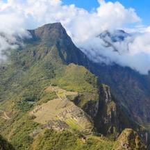 an aerial view of a mountain with clouds on it
