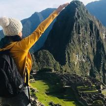 a person standing on top of a mountain with their arms outstretched