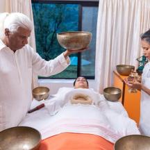a woman holding a bowl over a patient in a bed