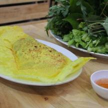 a plate with a tortilla and a salad on a table