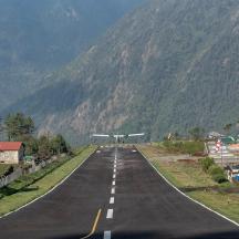an empty road with an airplane on the side of a mountain