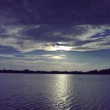 a large body of water with a cloudy sky
