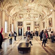 a group of people in a large room with paintings