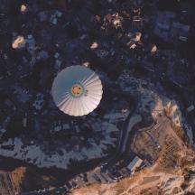 a hot air balloon flying over a city