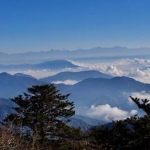 Blick auf eine Bergkette mit Wolken und Bäumen