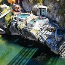 eine Luftaufnahme eines Swimmingpools an einem felsigen Fluss