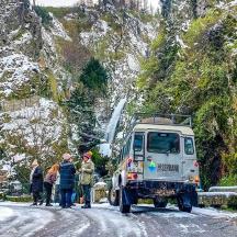 a group of people standing on a snow covered road