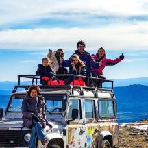 a group of people sitting on the roof of a van